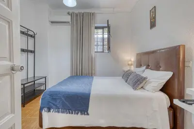 a bedroom with a bed with a blue and white blanket at Hotel Borsalino in Porto