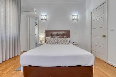 a bedroom with a large bed with white sheets at Hotel Borsalino in Porto