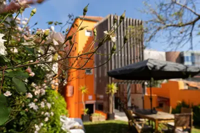 a garden with an umbrella and chairs and a table at Peach Hostel & Suites in Porto