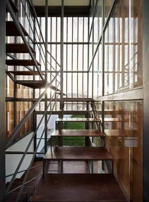 a spiral staircase in a building with a large window at Peach Hostel & Suites in Porto