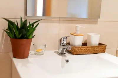 a bathroom sink with a basket of toiletries on it at Peach Hostel & Suites in Porto