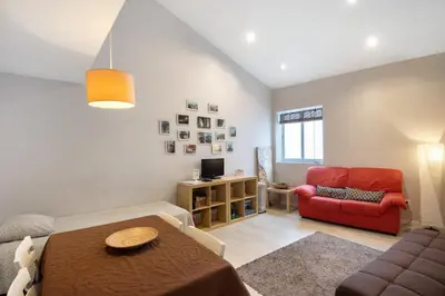 a living room with a table and a red chair at Sweet House In Oporto Center in Porto