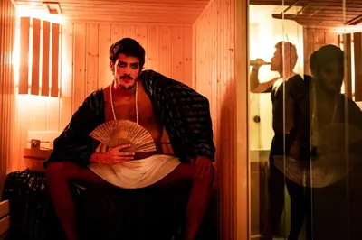 a man sitting on a chair holding a fan at Zero Box Lodge Porto in Porto