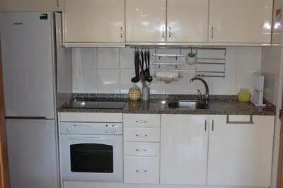 a kitchen with white cabinets and a sink at Galizia Flat in Porto
