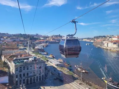 a gondola flying over a river in a city at Portus Vita Apartamento T0 Duplex in Vila Nova de Gaia