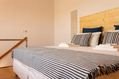 a bedroom with a large bed with blue and white sheets at Portus Vita Apartamento T0 Duplex in Vila Nova de Gaia