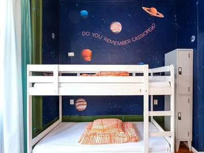 a childs bunk bed with a mural of planets at SUPERNOVA Hostel in Porto