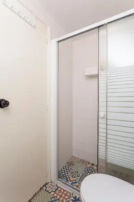 a shower with a glass door in a bathroom at SUPERNOVA Hostel in Porto