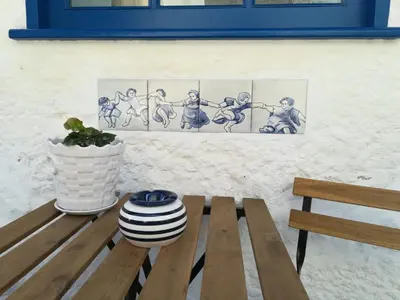 a wooden bench sitting next to a wall with four paintings at J3M Houses in Porto