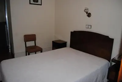 a bedroom with a bed and two chairs at Hotel Peninsular- Porto in Porto