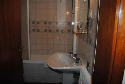 a bedroom with a wooden bed and two night stands at Hotel Peninsular- Porto in Porto