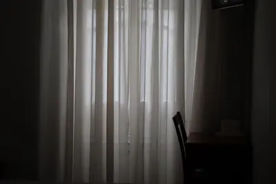 a white curtain in a room with a chair at Hotel Peninsular- Porto in Porto