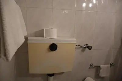 a bathroom with a toilet with a roll of toilet paper at Hotel Peninsular- Porto in Porto