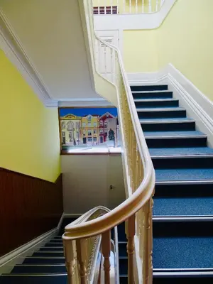 a staircase in a building with a painting on the wall at Poveira Hotel in Porto