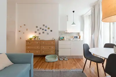 a living room with a blue couch and a table at Light Blue Apartment in Porto