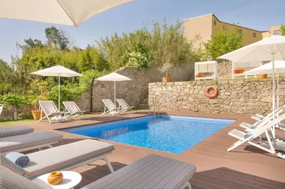 a pool with chairs and umbrellas in a yard at UMA Santa Catarina - Pool & Fitness, Adults Only in Porto