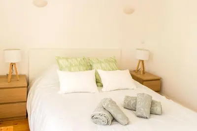 a bedroom with a white bed with two lamps at Guest H4U - Bonjardim Terrasse Center in Porto
