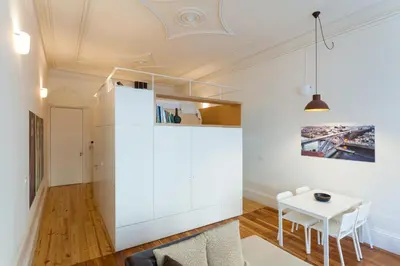 a living room with a white refrigerator and a table at Loft Ribeira - 3px - Spacious Flat in Porto