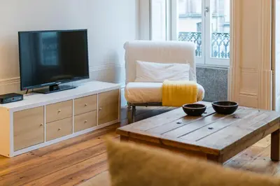 a living room with a television and a wooden coffee table at Loft Ribeira - 3px - Spacious Flat in Porto
