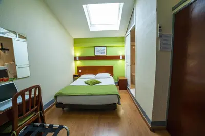 a bedroom with a bed and a skylight at Hotel Estoril Porto in Porto