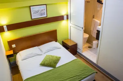 a small bedroom with a bed and a bathroom at Hotel Estoril Porto in Porto