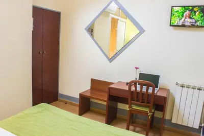 a bedroom with a desk with a chair and a mirror at Hotel Estoril Porto in Porto