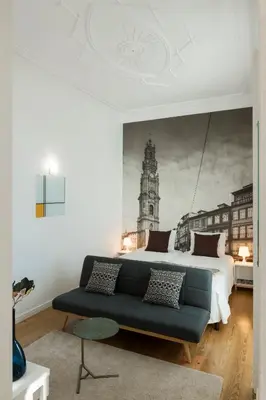 a bedroom with a king sized bed and a blue couch at naBaixa Apartments in Porto