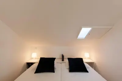 a bedroom with a bed with two black pillows at naBaixa Apartments in Porto