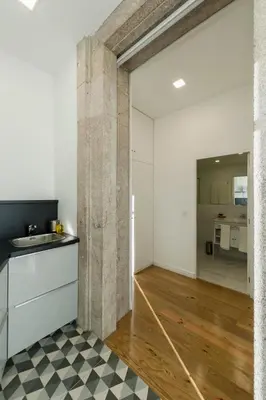 an open kitchen and living room with a stone wall at naBaixa Apartments in Porto