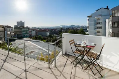 a balcony with a table and chairs on the roof at naBaixa Apartments in Porto