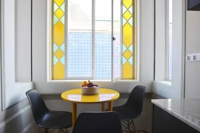 a yellow table and chairs in a kitchen with windows at YOUROPO - Market in Porto