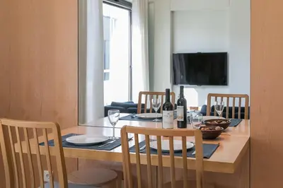 a dining room table with two chairs and a table with wine glasses at Inn Oporto Downtown New Apartments in Porto