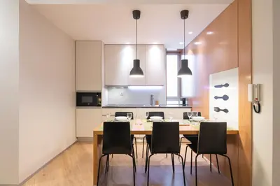 a kitchen with a wooden table and black chairs at Oportments - Oliveiras in Porto