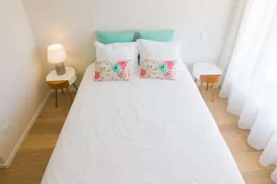 a bed with white sheets and pillows in a room at MH Duo in Porto