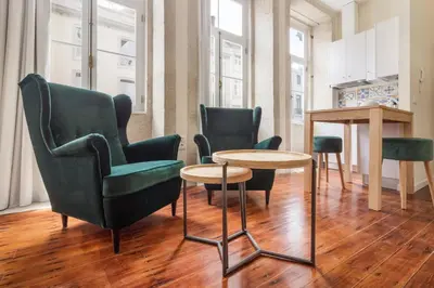 a living room with two chairs and a table and a tableablish at FAISAMA • Porto Apartments in Porto