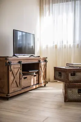 a television on a wooden entertainment center in a room at Alma Invicta Alegria in Porto