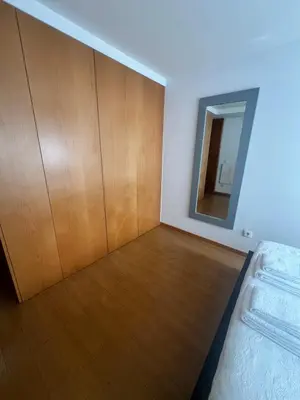 a bedroom with a wooden closet and a mirror at Maestro Appartment in Porto