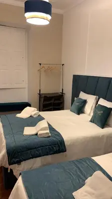 two beds sitting next to each other in a room at A Portuguesa Guest House in Porto