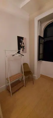 a room with a table and a chair and a window at A Portuguesa Guest House in Porto