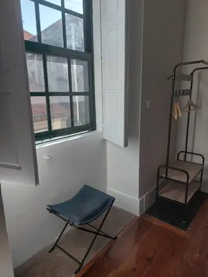 a room with a blue chair and a window at A Portuguesa Guest House in Porto