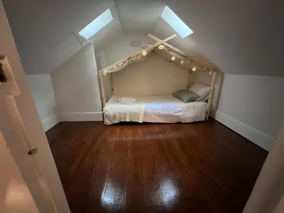 an attic room with a bed with lights on it at A Portuguesa Guest House in Porto