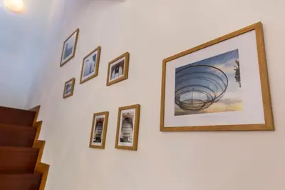 a group of framed pictures on a wall next to a staircase at Sunset Relaxing Apt with terrace, parking & bikes in Porto