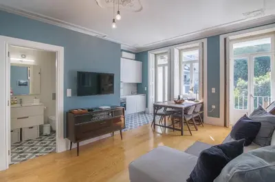 a living room with a couch and a table at Central location with garden & equipped kitchen in Porto