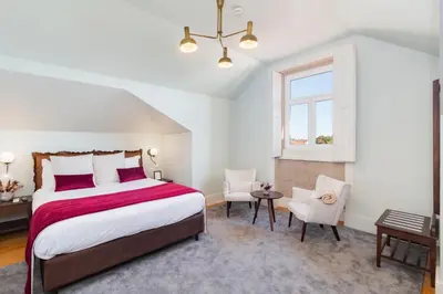 a hotel room with a large bed and a desk at Marquês Garden House by Olivia in Porto