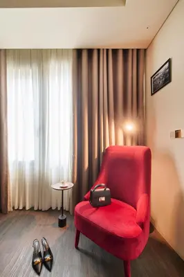 a red chair in a room with a table and shoes at Hotel Moon & Sun Porto in Porto