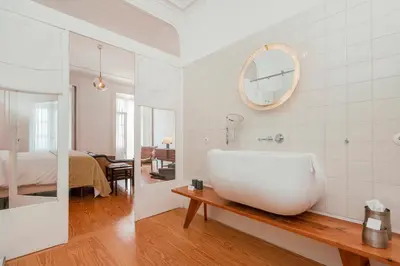a living room with a chair and a lamp at Rosa Et Al Townhouse in Porto