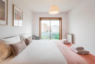 a large white bed in a room with a window at GuestReady - Jazz Apartment in Porto