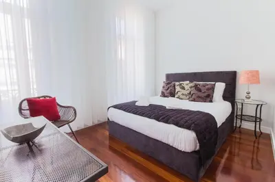 a bedroom with a bed and a chair and a table at Cool Terrace Apartment in Porto