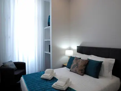 a bedroom with a bed with two pairs of shoes on it at Cool Terrace Apartment in Porto