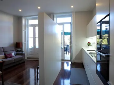 a kitchen and a living room with a couch at Cool Terrace Apartment in Porto